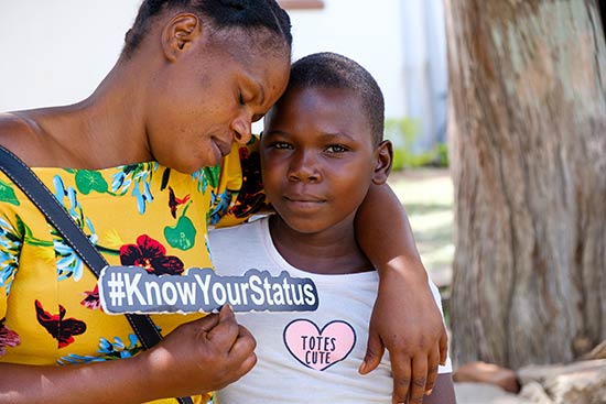 mother and child holding sign to know your hiv status